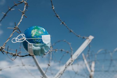 Dünya 'daki cerrahi maske. Salgın hastalık konsepti. Covid-19 / Coronavirus virüsü bulaşmış bir dünya. 