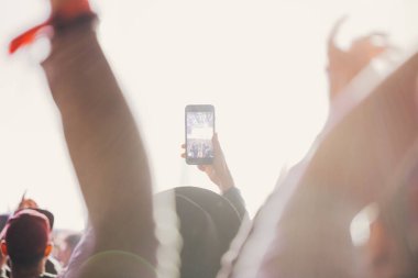 Sahne ışıkları ve bir müzik festivalinde elleri havada seyirci kalabalığı. Taraftarlar parti havasını seviyor.