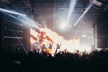 Sahne ışıkları ve bir müzik festivalinde elleri havada seyirci kalabalığı. Taraftarlar parti havasını seviyor.