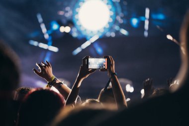 Sahne ışıkları ve bir müzik festivalinde elleri havada seyirci kalabalığı. Taraftarlar parti havasını seviyor.