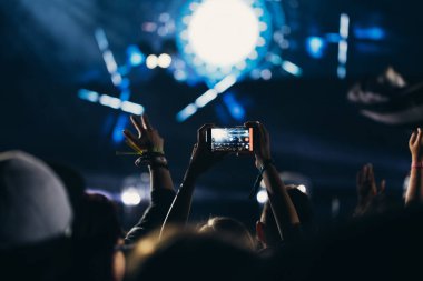 Sahne ışıkları ve bir müzik festivalinde elleri havada seyirci kalabalığı. Taraftarlar parti havasını seviyor.