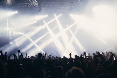 Sahne ışıkları ve bir müzik festivalinde elleri havada seyirci kalabalığı. Taraftarlar parti havasını seviyor.