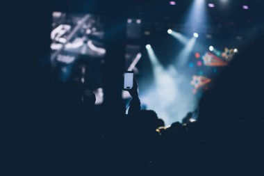 Sahne ışıkları ve bir müzik festivalinde elleri havada seyirci kalabalığı. Taraftarlar parti havasını seviyor.