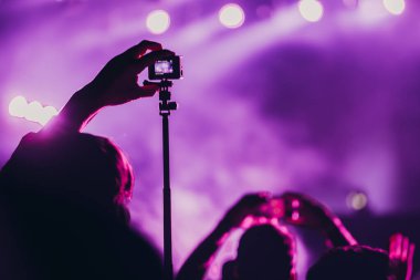 Sahne ışıkları ve bir müzik festivalinde elleri havada seyirci kalabalığı. Taraftarlar parti havasını seviyor.