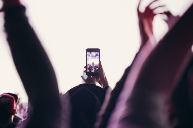 Sahne ışıkları ve bir müzik festivalinde elleri havada seyirci kalabalığı. Taraftarlar parti havasını seviyor.