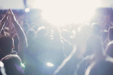 Sahne ışıkları ve bir müzik festivalinde elleri havada seyirci kalabalığı. Taraftarlar parti havasını seviyor.