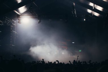 Sahne ışıkları ve bir müzik festivalinde elleri havada seyirci kalabalığı. Taraftarlar parti havasını seviyor.