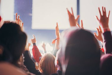 Sahne ışıkları ve bir müzik festivalinde elleri havada seyirci kalabalığı. Taraftarlar parti havasını seviyor.