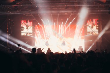Sahne ışıkları ve bir müzik festivalinde elleri havada seyirci kalabalığı. Taraftarlar parti havasını seviyor.