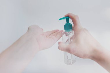 Male hand using sanitizer to disinfect from Covid-19 bacteria.  clipart