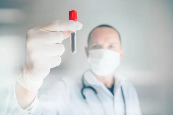 Doktorun Covid-19 testi pozitif çıktı. Coronavius salgını krizi. Laboratuvarda bir tüpte kan örneği.. 