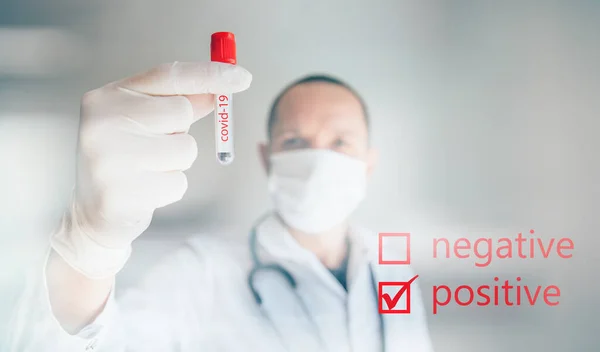 Doktorun Covid-19 testi pozitif çıktı. Coronavius salgını krizi. Laboratuvarda bir tüpte kan örneği.. 
