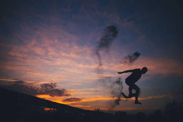 석양에 모래를 뛰어드는 사람의 실루엣 — 스톡 사진