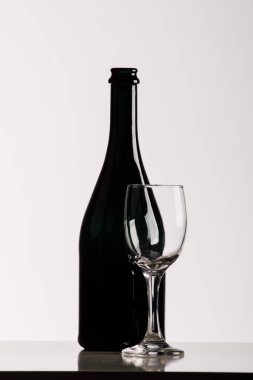 Beyaz arka planda şarap şişesi ve cam.