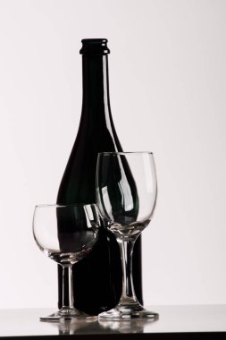 Beyaz arka planda şarap şişesi ve gözlük.