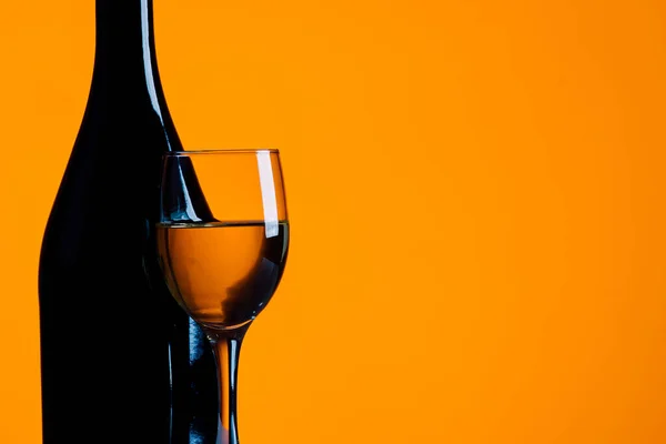 wine bottle and glass on a yellow background