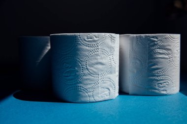 Tuvalet kağıdı mavi arka planda. Salgın sırasında panik alışverişi.