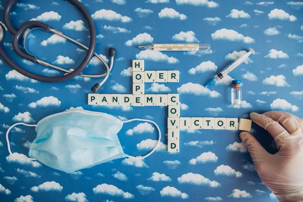 Flat lay of board game with letters about pandemic outbreak. Victory themed image when Covid-19 is over.