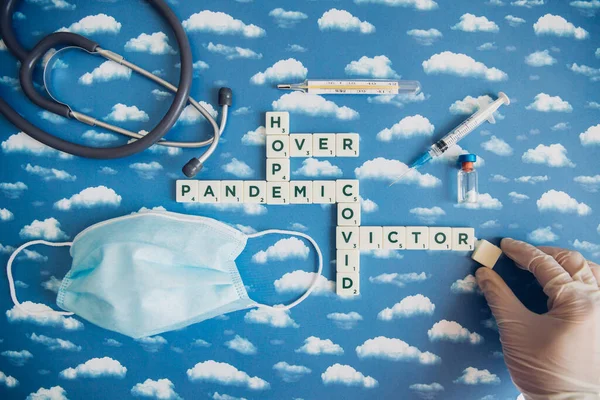 Flat lay of board game with letters about pandemic outbreak. Victory themed image when Covid-19 is over.