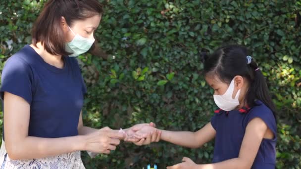 アジアの母親と娘はアルコール消毒ジェルを使用し 予防マスクを着用し Covid 19感染症の感染を予防し 手消毒剤で手を洗うことでコロナウイルスの汚染を避ける — ストック動画