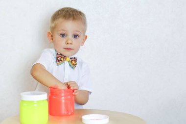 Küçük çocuk oyun masasında sümükle oynuyor, küçük çocuklarda iyi motor becerileri geliştirmek için harika bir aktivite. 