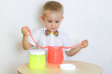 Küçük çocuk oyun masasında sümükle oynuyor, küçük çocuklarda iyi motor becerileri geliştirmek için harika bir aktivite. 