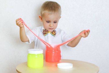 Küçük çocuk oyun masasında sümükle oynuyor, küçük çocuklarda iyi motor becerileri geliştirmek için harika bir aktivite. 
