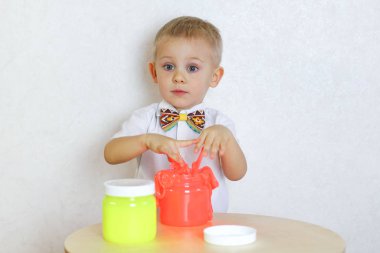 Küçük çocuk oyun masasında sümükle oynuyor, küçük çocuklarda iyi motor becerileri geliştirmek için harika bir aktivite. 
