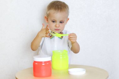 Küçük çocuk oyun masasında sümükle oynuyor, küçük çocuklarda iyi motor becerileri geliştirmek için harika bir aktivite. 