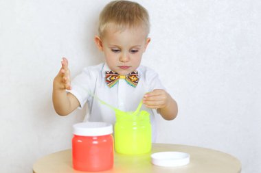 Küçük çocuk oyun masasında sümükle oynuyor, küçük çocuklarda iyi motor becerileri geliştirmek için harika bir aktivite. 