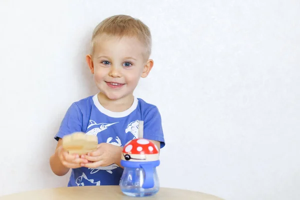 Carino Ragazzo Biondo Sorridente Seduto Tavolo Gioco Sua Bottiglia Acqua — Foto Stock