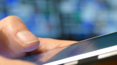 Erkekler parmaklarını dokunmatik ekranlı akıllı telefona basıyor, akıllı telefonu yakın planda kullanıyor.