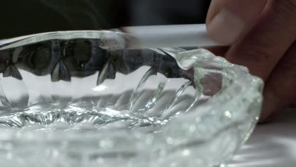 Un fumeur qui met la cigarette dans le cendrier. Gros plan de la main d'un fumeur à l'aide du cendrier 