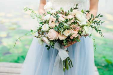 Çiçek buketi gelin kollarında