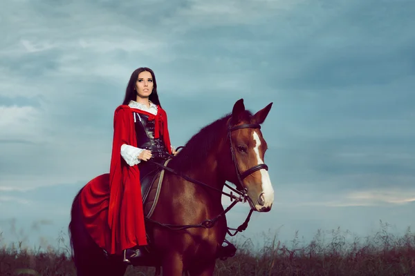 Güzel prenses kırmızı pelerin ile bir at binme — Stok fotoğraf