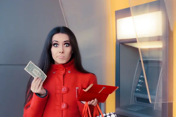 Broke Woman Holding One Dollar in Front of an ATM