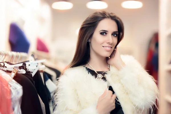 Mujer de compras vestida con abrigo de piel blanca en la tienda de moda —  Fotos de Stock