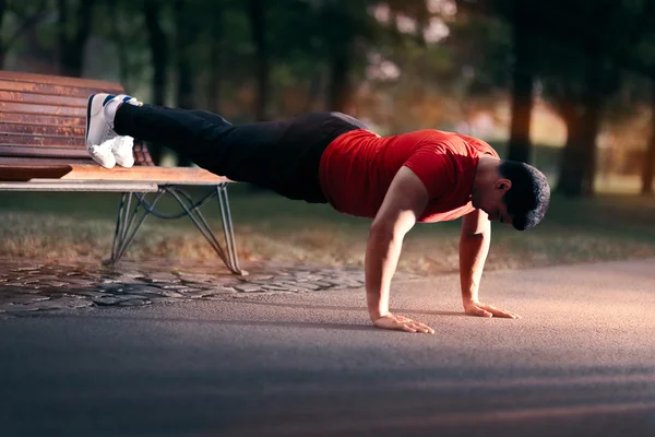 Fitness Man faire un banc de presse vers le haut à l'extérieur — Photo