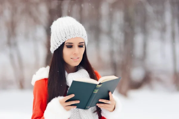 Zimní žena čte knihu venku na sněhu — Stock fotografie