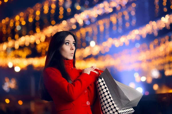 Nieuwsgierige vrouw met boodschappentassen in kerstmarkt — Stockfoto