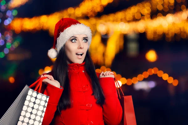 Mujer asombrada con bolsas de compras en la feria de Navidad —  Fotos de Stock