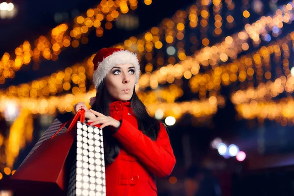 Překvapený vánoční žena s nákupní tašky — Stock fotografie