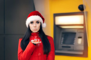 Disappointed woman with Small Gift Box in Front of an ATM clipart