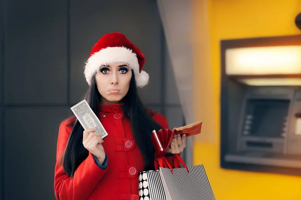 Vánoční žena držící jeden dolar před Atm — Stock fotografie