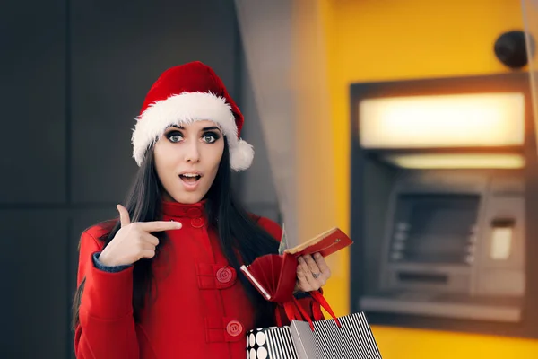 Mujer de Navidad revisando su billetera frente a un cajero automático del banco —  Fotos de Stock