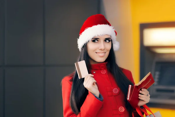 Счастливая покупательница держит кредитную карту перед банкоматом — стоковое фото