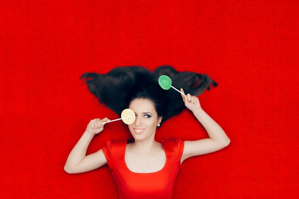 Mulher bonita com pirulitos em fundo vermelho — Fotografia de Stock