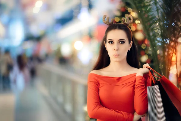 Legrační žena s Vánoční sobí rohy čelenka nakupování — Stock fotografie