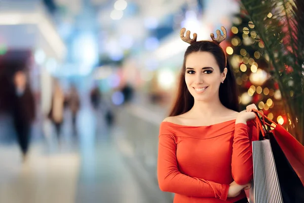 Nákupní žena nosí Vánoční sobí rohy čelenka — Stock fotografie