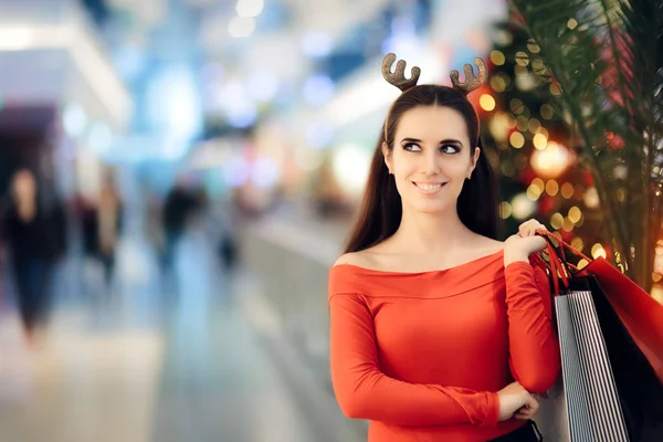 Shopping kvinna bär Christmas renar horn pannband — Stockfoto